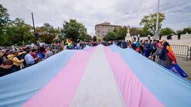 Marchers unfurl the transgender flag. Photo by Erik McGregor/LightRocket via Getty Images