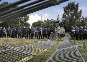 Police in riot gear in front of the statue of Confederate General Robert E. Lee